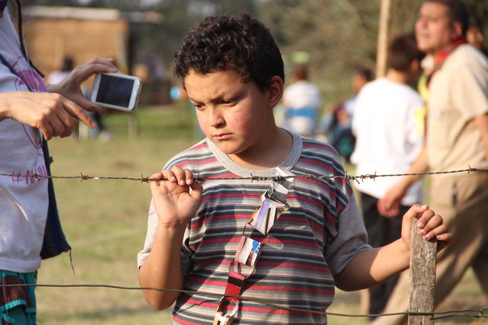 Niño frente a alambre de puas